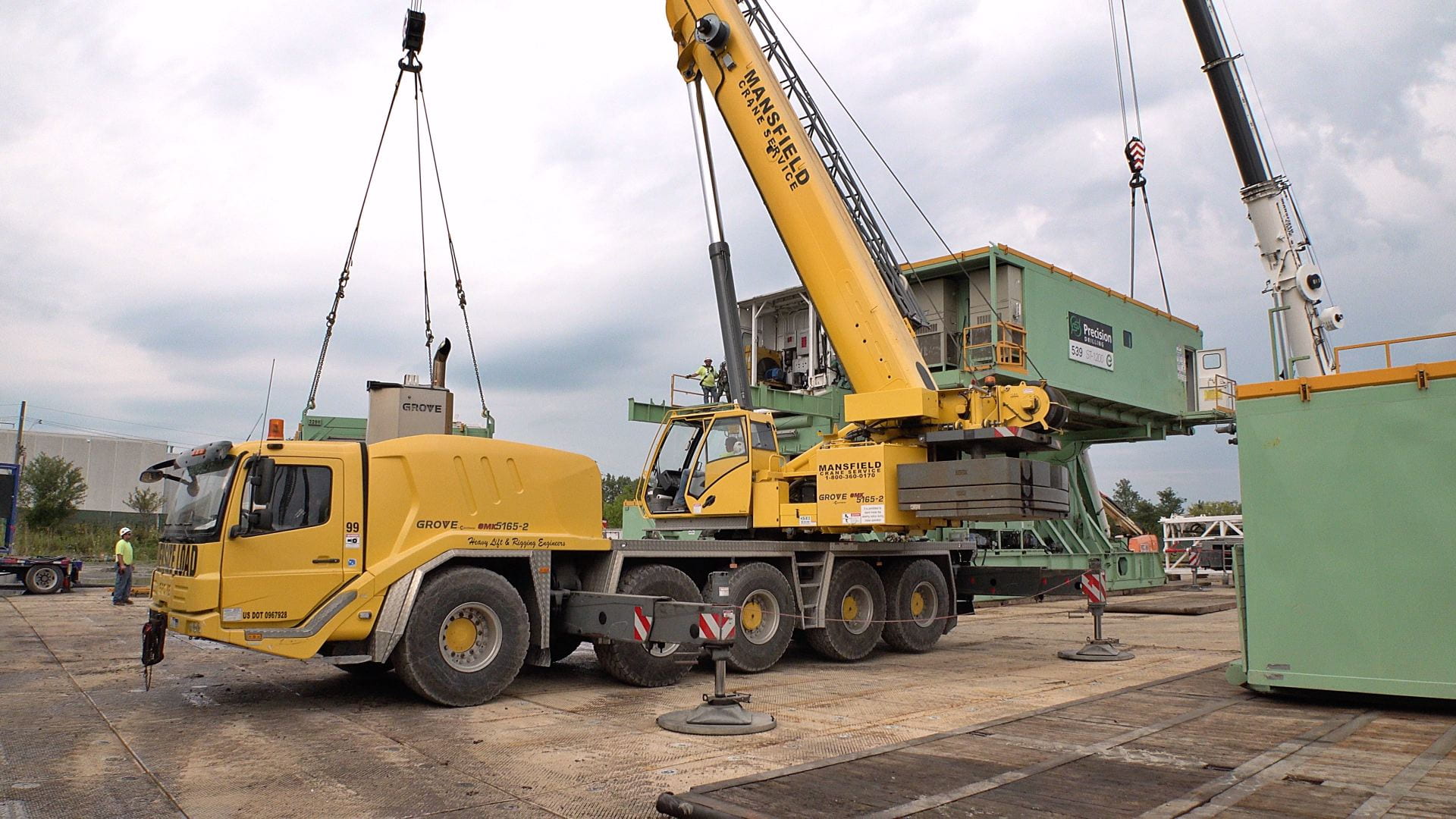 One of the trailer units is lifted by crane for removal from the CUBO site.